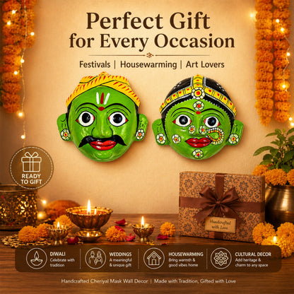 Two green Chiriyal mask wall decor pieces on a decorative background with candles and flowers.